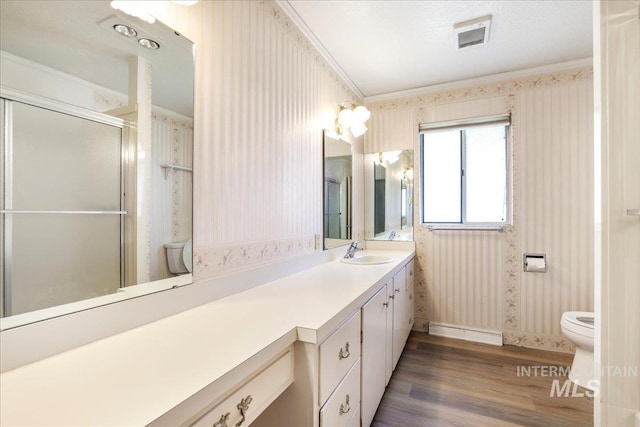 2011 Schodde, Burley, ID 83318 - bathroom featuring wallpapered walls, toilet, wood finished floors, vanity, and ornamental molding