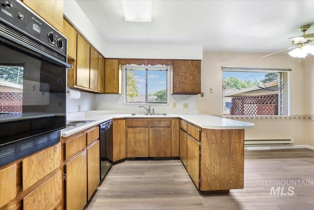 2011 Schodde, Burley, ID 83318 - kitchen with a peninsula, baseboard heating, black appliances, and brown cabinets