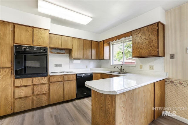 2011 Schodde, Burley, ID 83318 - kitchen with black appliances, a sink, a peninsula, wallpapered walls, and light countertops