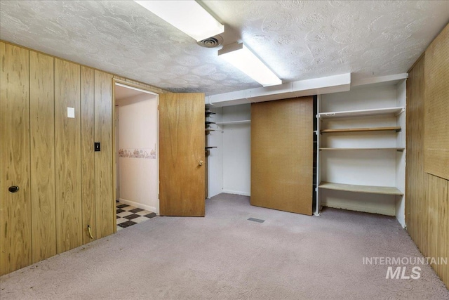 2011 Schodde, Burley, ID 83318 - unfurnished bedroom with wooden walls, a textured ceiling, carpet flooring, and a closet