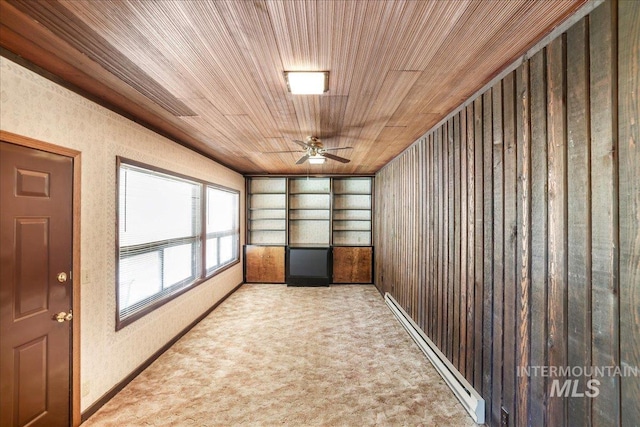 2011 Schodde, Burley, ID 83318 - spare room with baseboard heating, wooden ceiling, a ceiling fan, carpet flooring, and wooden walls