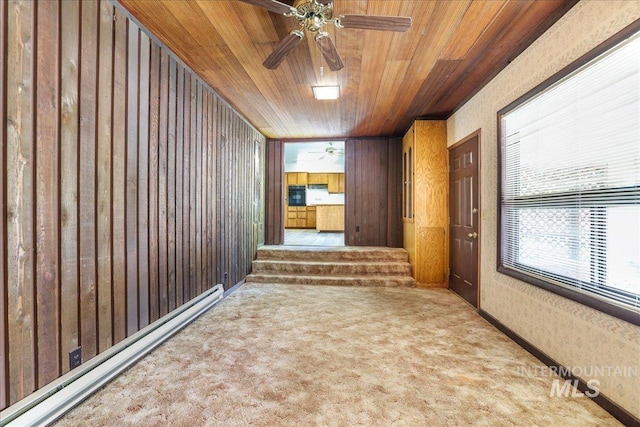 2011 Schodde, Burley, ID 83318 - carpeted spare room featuring wood ceiling, wood walls, a ceiling fan, and baseboard heating