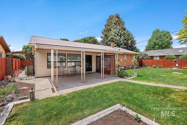 2011 Schodde, Burley, ID 83318 - rear view of house with metal roof, a patio area, and a chimney