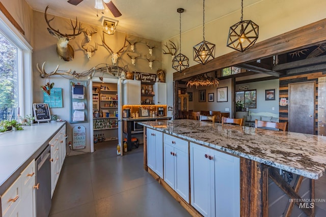 kitchen with white cabinets, a breakfast bar area, hanging light fixtures, and dishwasher