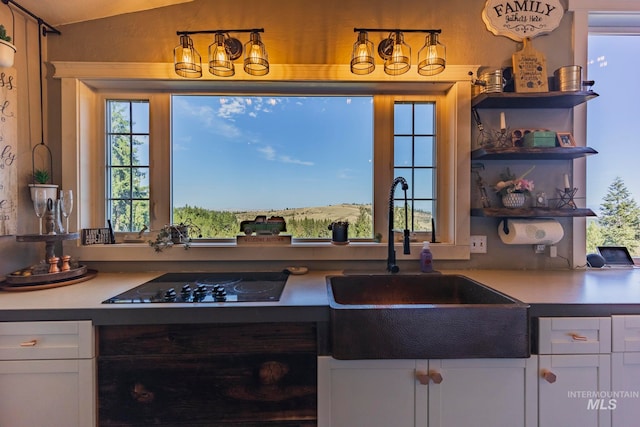 kitchen featuring white cabinets, black electric stovetop, and sink