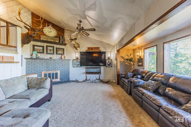 living room featuring lofted ceiling, a brick fireplace, wooden walls, carpet, and ceiling fan