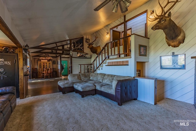 living room featuring vaulted ceiling, ceiling fan, and wood walls