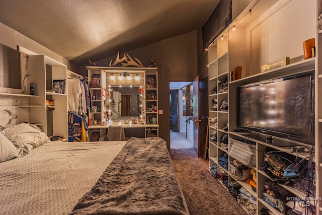 bedroom with a textured ceiling, carpet, and lofted ceiling