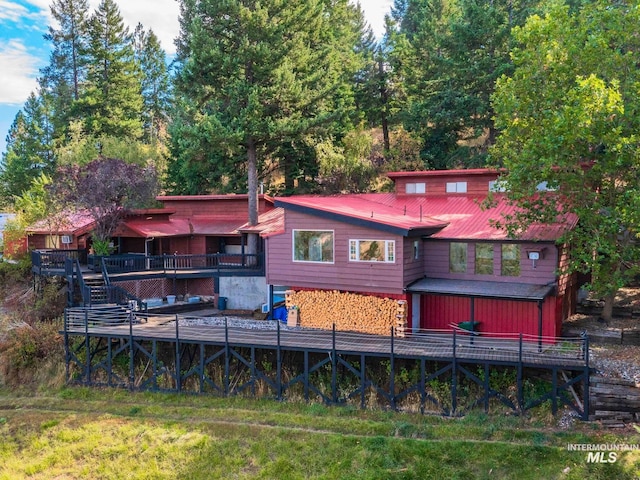 rear view of property featuring a deck and a yard