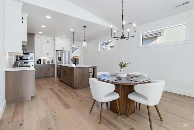 dining space with sink and light hardwood / wood-style flooring