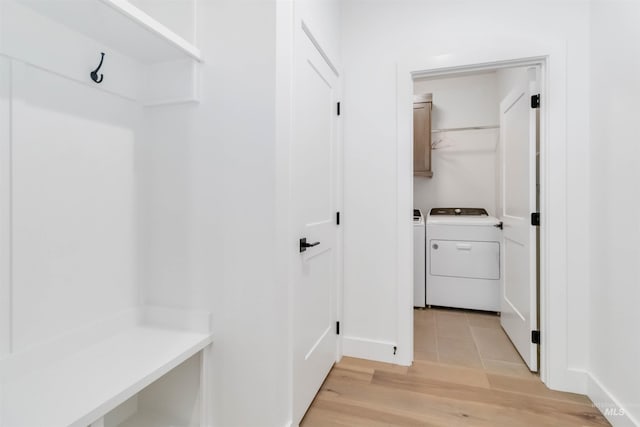 mudroom with washing machine and clothes dryer and light hardwood / wood-style flooring