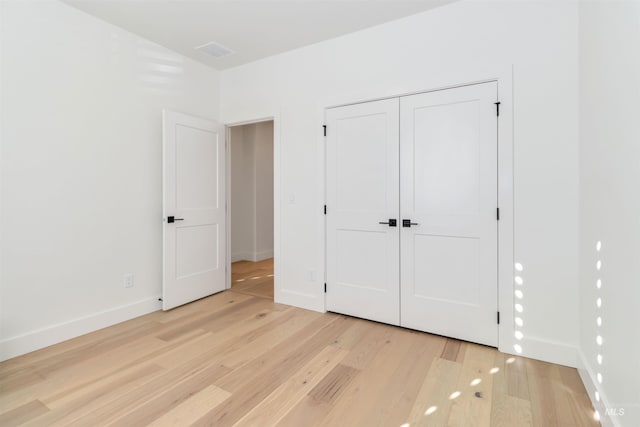 unfurnished bedroom with light hardwood / wood-style floors and a closet