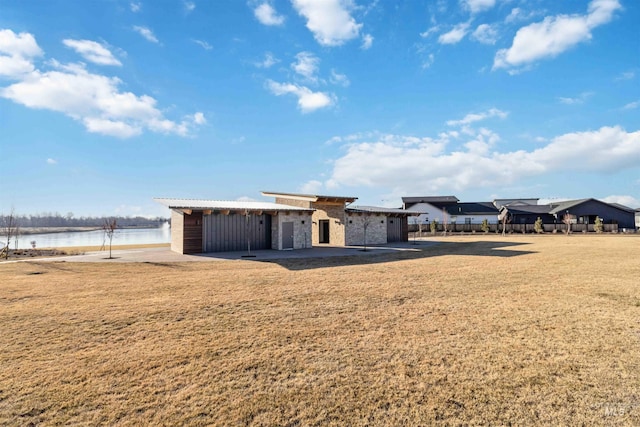 exterior space featuring a water view and a front lawn