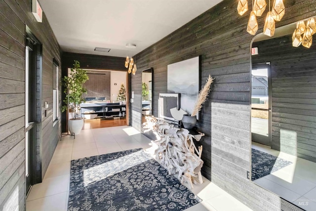 interior space with light tile patterned floors and wooden walls