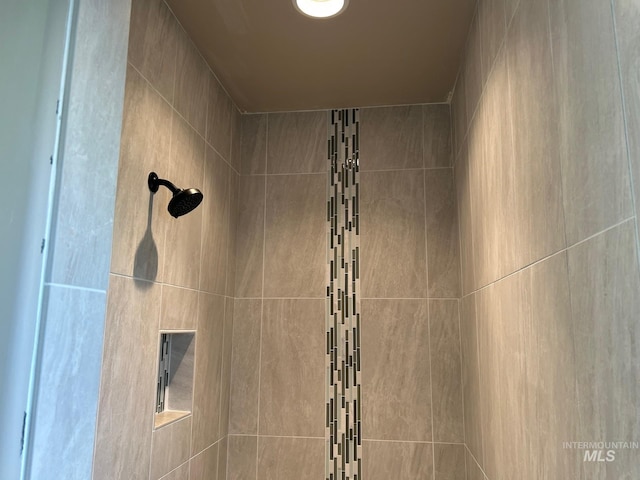 interior details with a tile shower