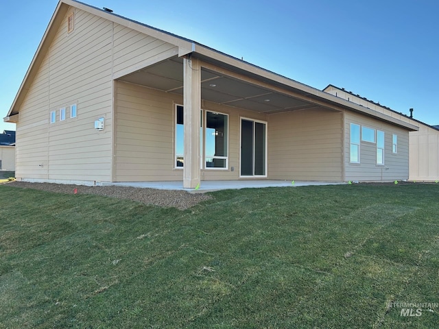 back of property featuring a lawn