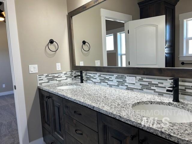 bathroom featuring a wealth of natural light, backsplash, and vanity