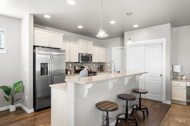 11661 W Baserri, Boise, ID 83709 - kitchen with appliances with stainless steel finishes, dark wood-style flooring, backsplash, a breakfast bar, and recessed lighting