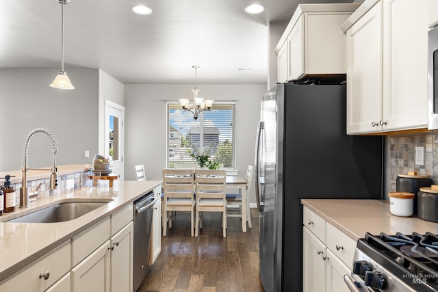 11661 W Baserri, Boise, ID 83709 - kitchen featuring a sink, stainless steel appliances, a chandelier, dark wood-style floors, and decorative backsplash