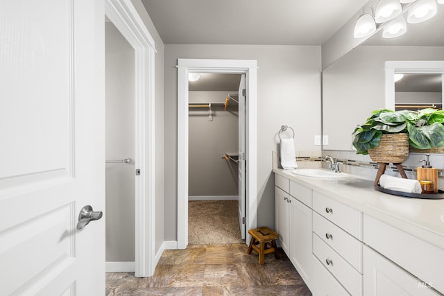 11661 W Baserri, Boise, ID 83709 - bathroom featuring vanity, a spacious closet, stone finish flooring, and baseboards