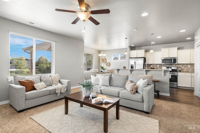 11661 W Baserri, Boise, ID 83709 - carpeted living room with a ceiling fan, baseboards, recessed lighting, and a chandelier