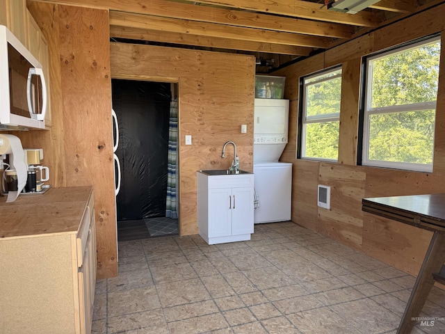 7 Ridgetop Pl, Boise, ID 83716 - washroom featuring stacked washing machine and dryer, wood walls, a sink, and heating unit