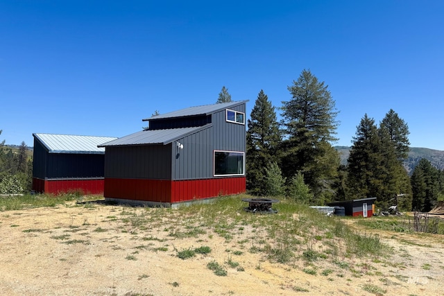 7 Ridgetop Pl, Boise, ID 83716 - view of side of home with metal roof, an outdoor fire pit, and an outdoor structure