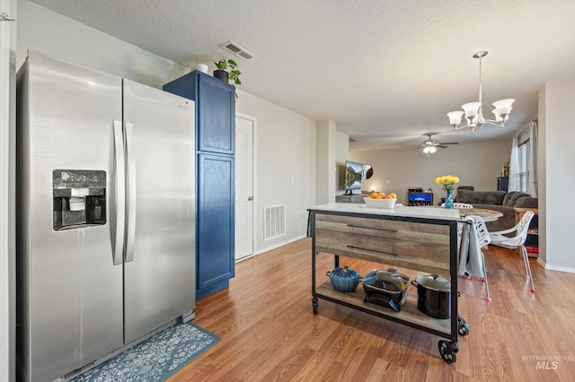 kitchen with blue cabinets, decorative light fixtures, stainless steel fridge with ice dispenser, and light wood-type flooring