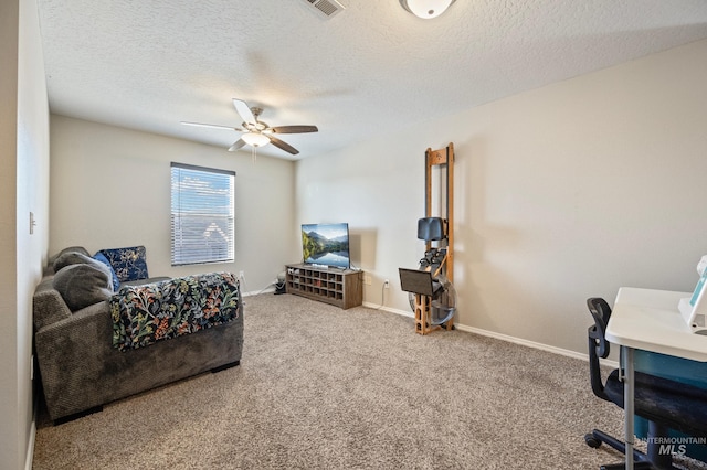 carpeted office with a textured ceiling and ceiling fan