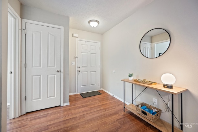 entrance foyer featuring wood-type flooring and a textured ceiling