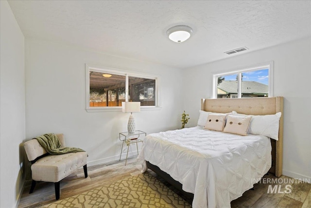 bedroom featuring wood-type flooring and a textured ceiling