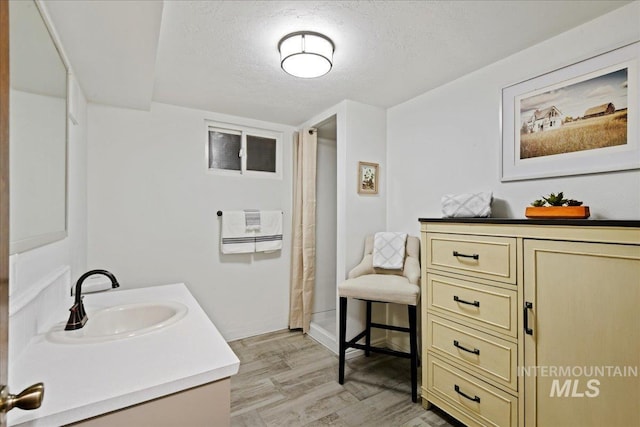 bathroom featuring vanity, wood-type flooring, a textured ceiling, and a shower with shower curtain