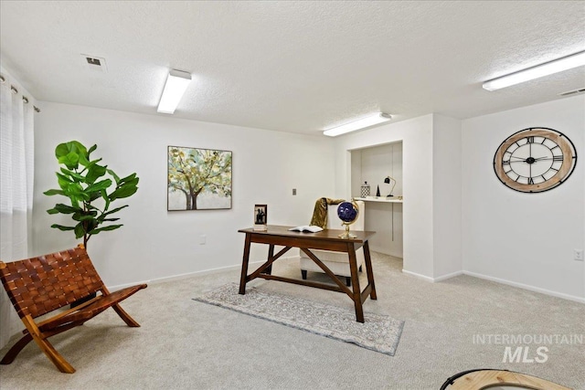 carpeted home office with a textured ceiling