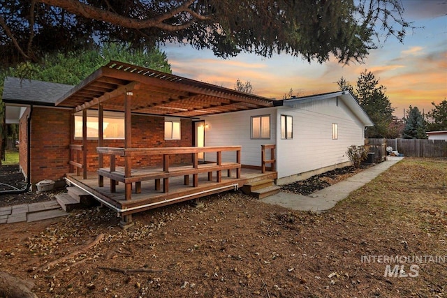 back house at dusk with a wooden deck