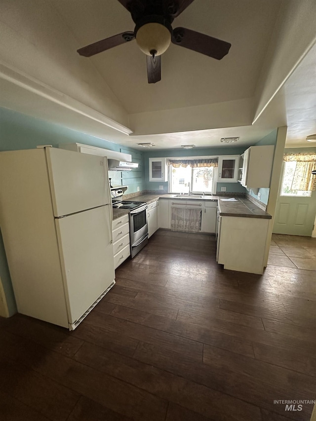 kitchen featuring electric stove, ceiling fan, lofted ceiling, dark wood-type flooring, and freestanding refrigerator