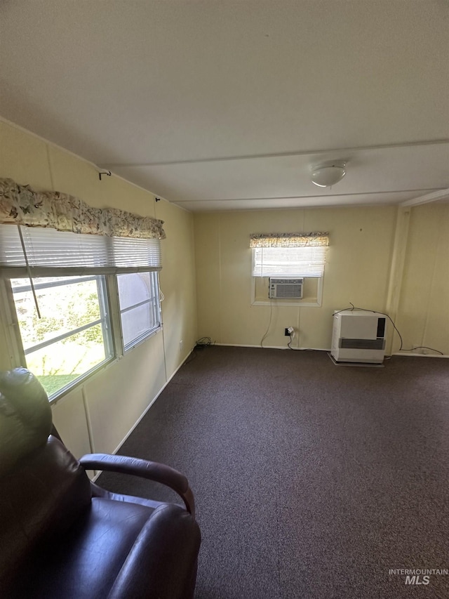 unfurnished room with dark carpet, plenty of natural light, and cooling unit