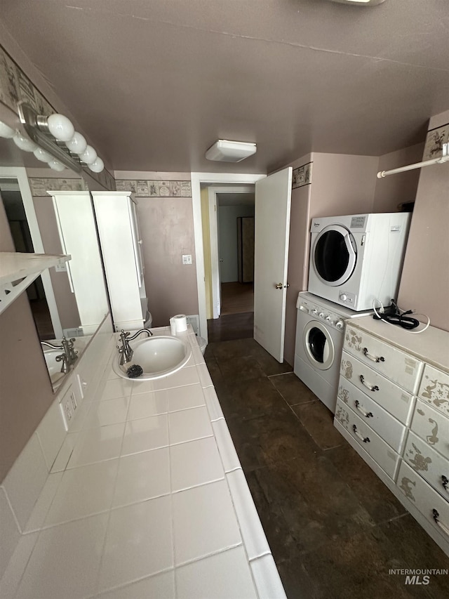 bathroom featuring stacked washer and dryer and a sink