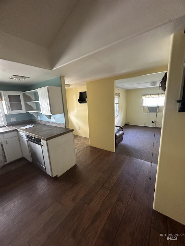 kitchen with stainless steel dishwasher, dark countertops, dark wood-type flooring, and white cabinetry