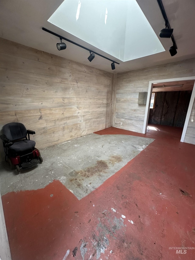 unfurnished living room featuring unfinished concrete floors and wooden walls