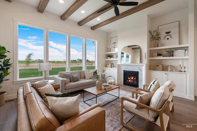 living room featuring beamed ceiling, ceiling fan, hardwood / wood-style floors, and built in features