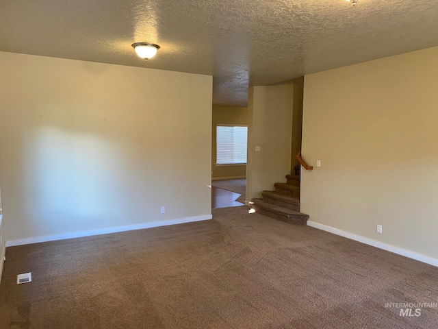 carpeted spare room with a textured ceiling