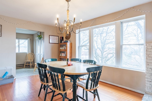 dining area with light wood-style floors, baseboards, and a chandelier