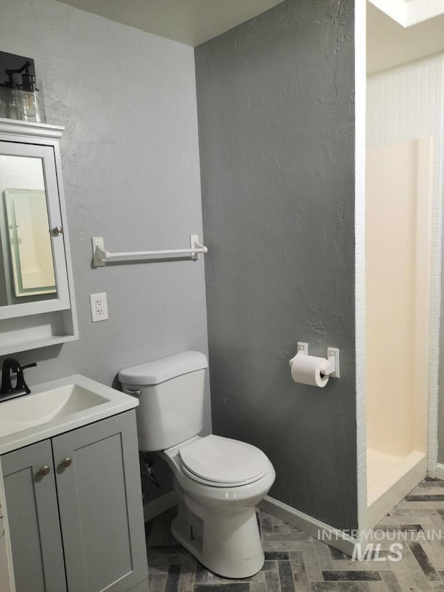 39992 Waha Glen Rd, Lewiston, ID 83501 - bathroom featuring toilet, a stall shower, baseboards, a textured wall, and vanity