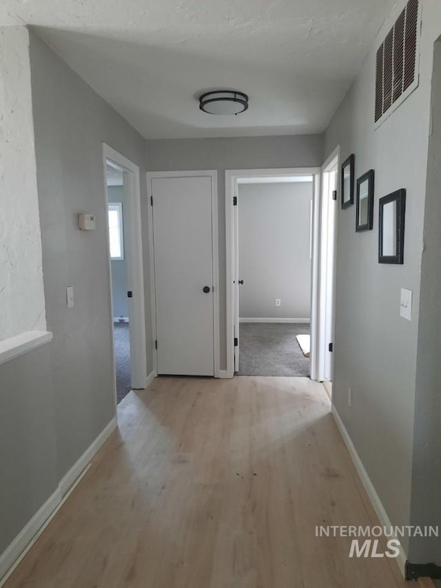 39992 Waha Glen Rd, Lewiston, ID 83501 - hall featuring light wood finished floors, baseboards, and visible vents