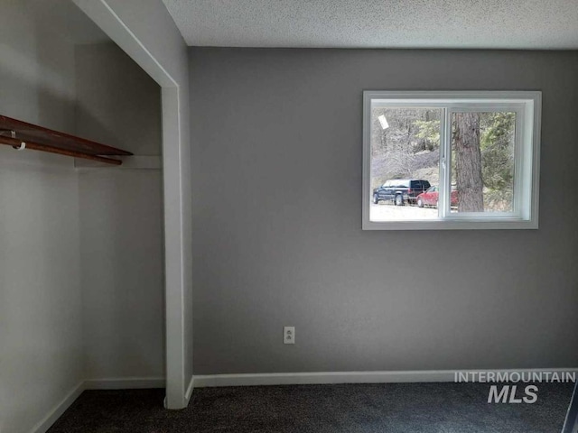 39992 Waha Glen Rd, Lewiston, ID 83501 - unfurnished bedroom with a textured ceiling, dark colored carpet, and baseboards