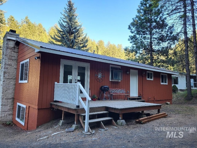 39992 Waha Glen Rd, Lewiston, ID 83501 - rear view of house with metal roof, a wooden deck, a chimney, and board and batten siding