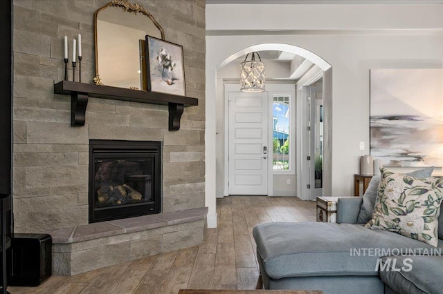 2357 N Synergy Pl, Eagle, ID 83616 - living area with arched walkways, wood-type flooring, and a glass covered fireplace