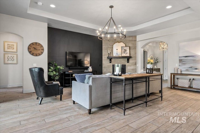 2357 N Synergy Pl, Eagle, ID 83616 - living area featuring a raised ceiling, arched walkways, light wood-style flooring, a chandelier, and recessed lighting