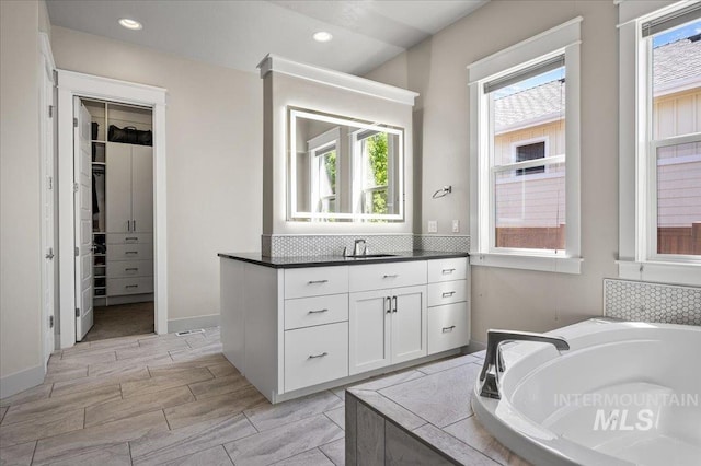 2357 N Synergy Pl, Eagle, ID 83616 - bathroom featuring healthy amount of natural light, a garden tub, vanity, tasteful backsplash, and recessed lighting
