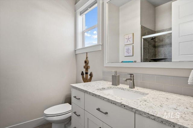 2357 N Synergy Pl, Eagle, ID 83616 - bathroom featuring vanity, decorative backsplash, a tile shower, toilet, and baseboards